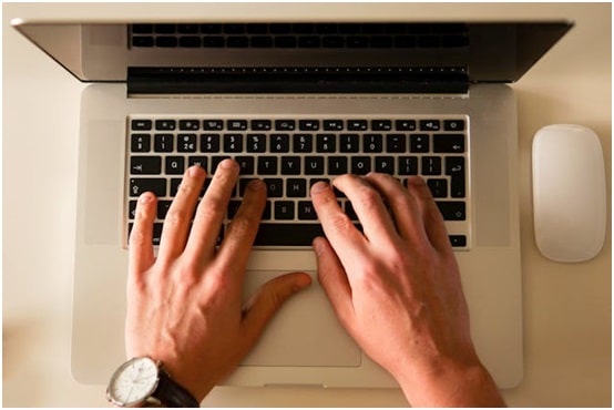 hands typing on a computer keyboard
